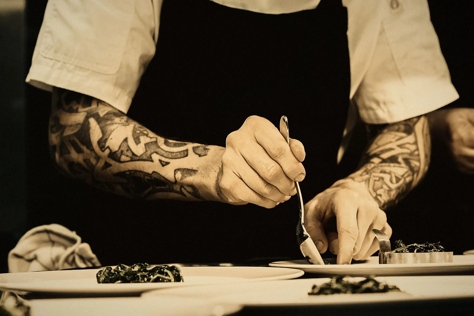 A chef plating fresh greens for a personalised meal plan