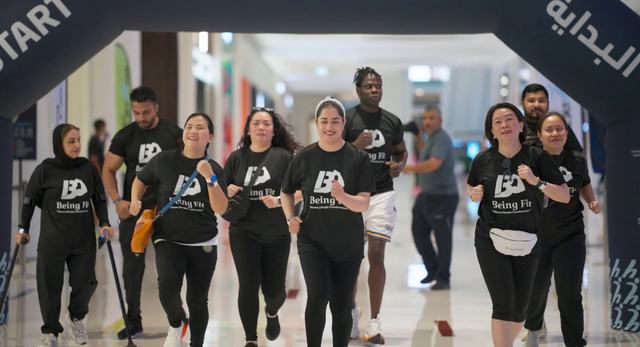 نساء يرتدين قمصان Being Fit، إحداهن ترتدي الحجاب، ينطلقن من قوس البداية في Dubai Mallathon في دبي مول